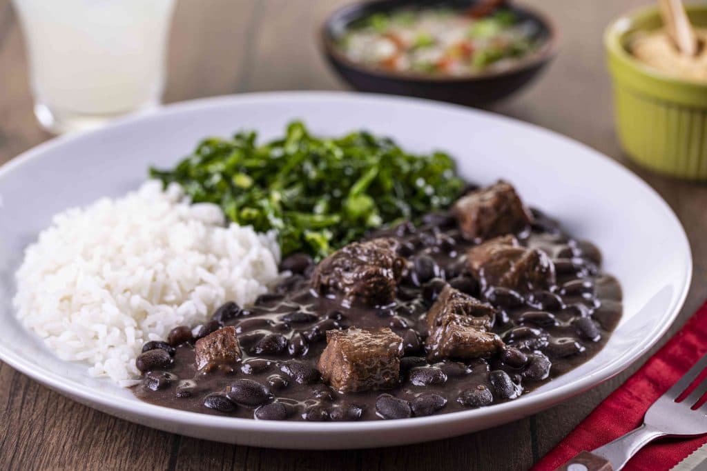 Brazilian feijoada with rice and leafy greens